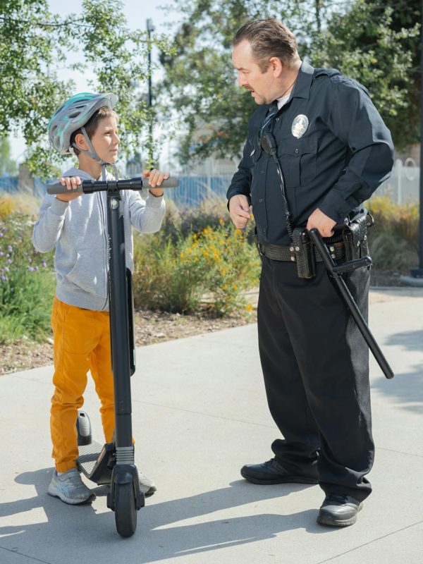 old policeman asks boy on electric scooter is he ok?