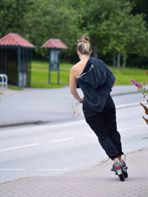 young woman ride electric scooters for commuting and turns left on the street